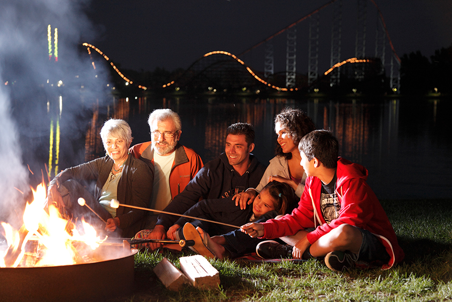 Family roasting marshmallows over campfire